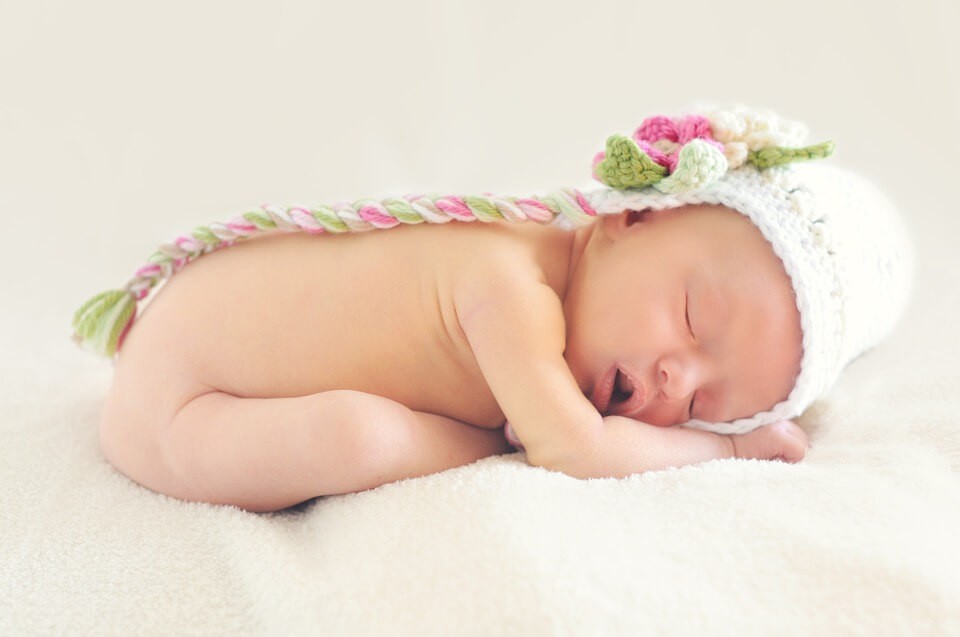 Happy sleeping baby doing yoga